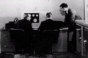 AlanTuring, right, at the console of the Manchester Computer.